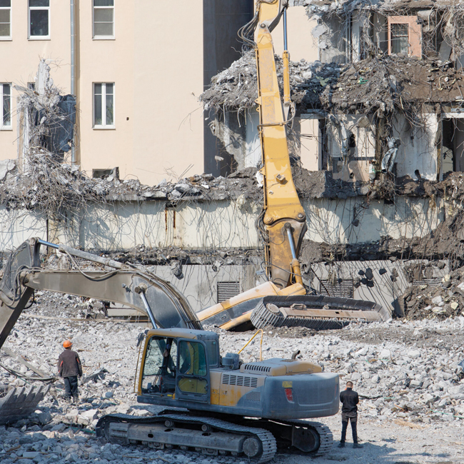 Our-Building-Demolition-Services- Young worker in red helmet and blue suit performing interior demolition