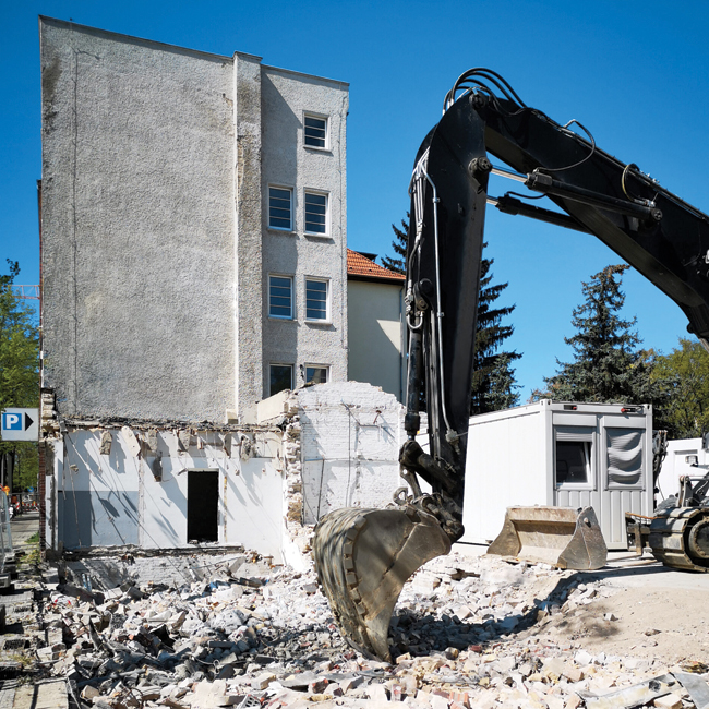 Our-House-Demolition-Services- Young worker in red helmet and blue suit performing interior demolition