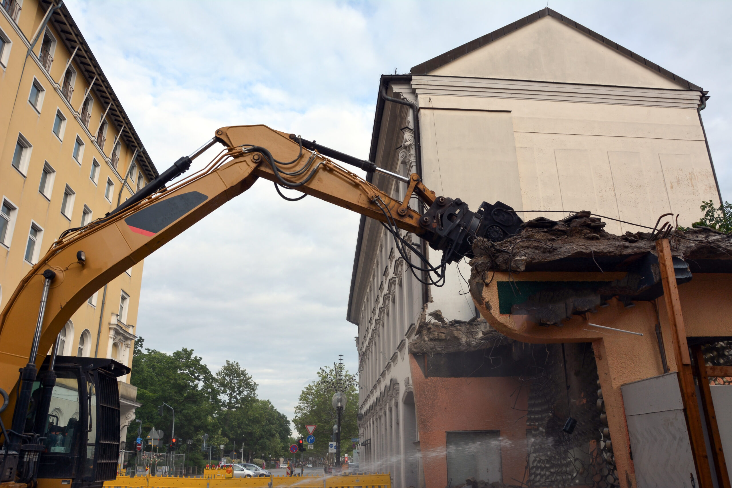 The-Problem--Outdated,-Damaged,-or-Unusable-Interiors1 Excavator tearing down building structure during house demolition in an urban area.